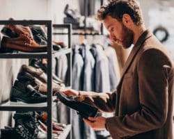 Young handsome man choosing shoes at a shop