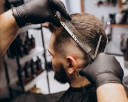 Client doing hair cut at a barber shop salon